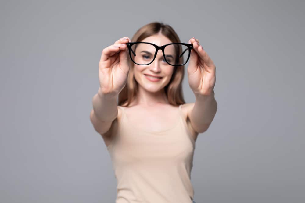 A woman trying on her Designer Persol Frames at our Nashville Eye Doctor