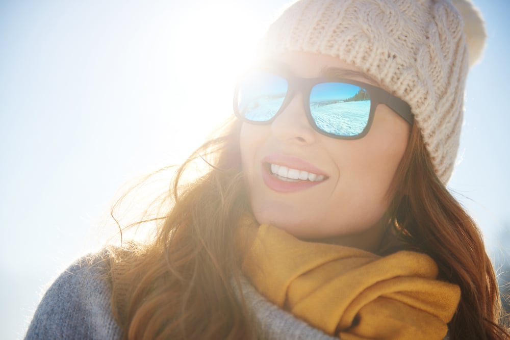 Woman wearing winter sunglasses while outside to protect her eyes