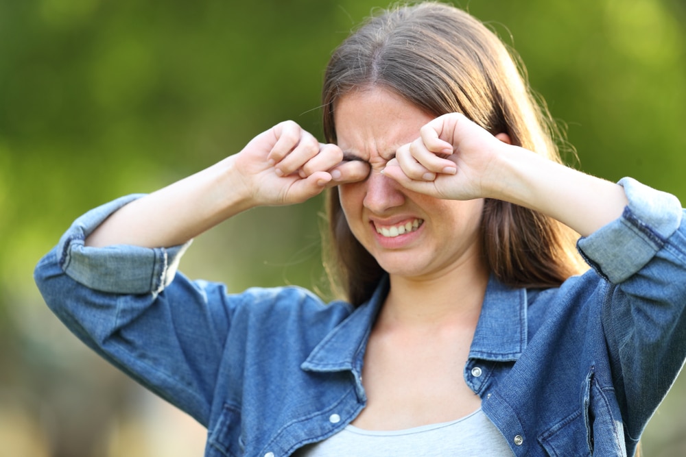 A woman rubbing her eyes and dealing with allergy eyes