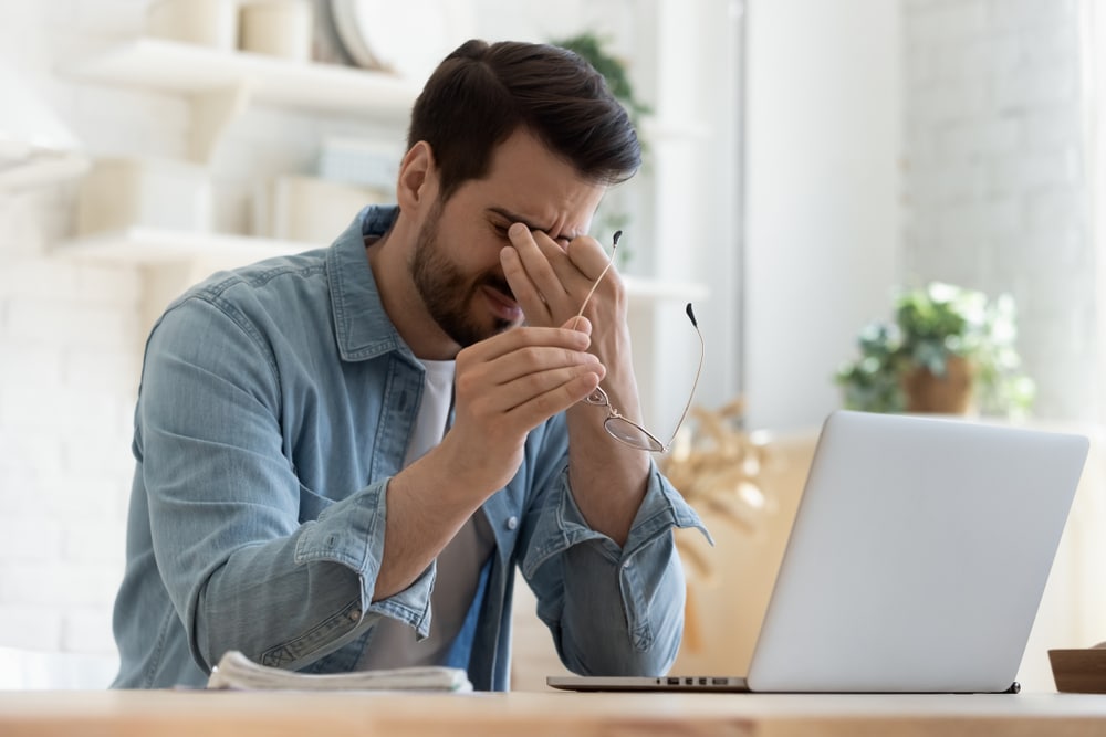 A man suffering from Digital eye strain symptoms and in need of glasses for digital eye strain