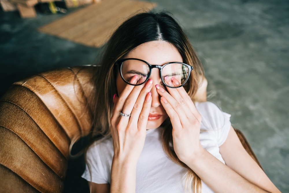 Woman rubbing tired eyes - learn why sleep matters for eye health
