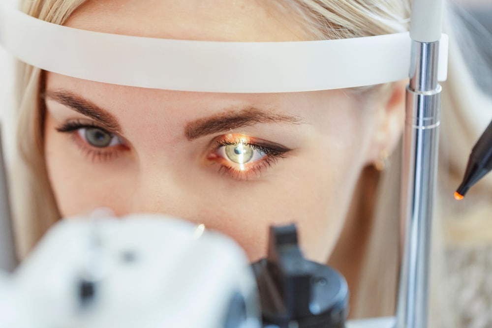 Women getting her eyes checked during a comprehensive Eye Exam - learn what not to do before an eye exam