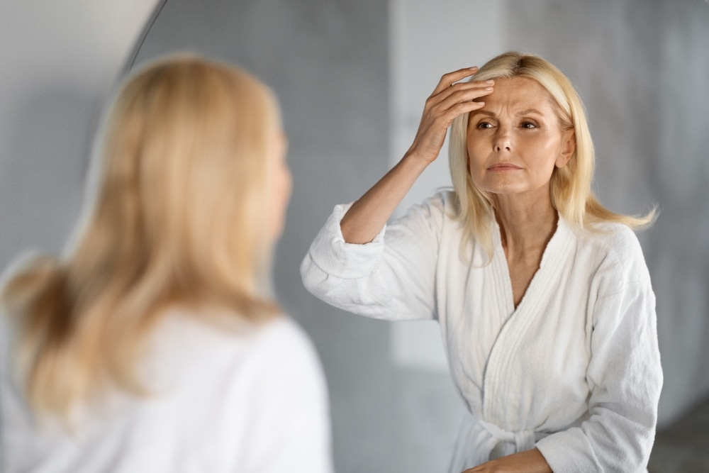 Woman looking in the mirror at potential wrinkles - a good candidate for RF Treatments in Nashville