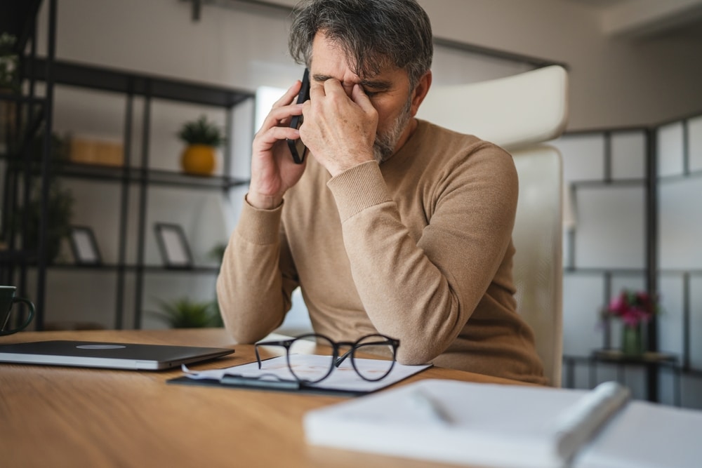 Man struggling with the symptoms of Astigmatism with tired eyes